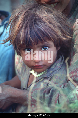 Portrait des petites brown-eyed Kashmiri enfant femelle avec des cheveux ébouriffés. Elle regarde directement dans l'appareil photo Banque D'Images