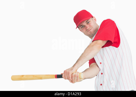 Portrait of young baseball player swinging bat Banque D'Images