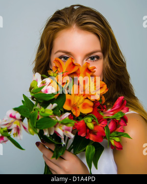 Visage de fleurs fille couvre l'alstroemeria. Photo dans le studio. Banque D'Images