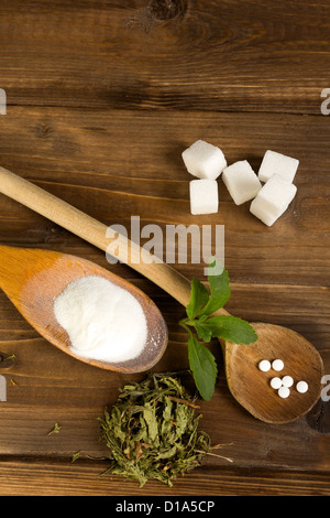 Les diverses formes de stévia édulcorant naturel plus du vrai morceaux de sucre sur une table en bois Banque D'Images