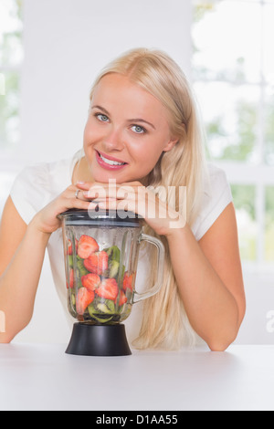 Femme mettant les mains sur le mélangeur Banque D'Images