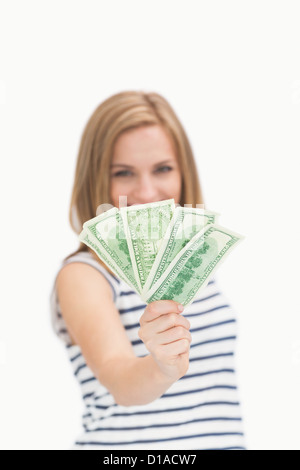 Portrait of happy young woman holding out attisa les billets de dollar Banque D'Images