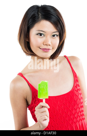 Chinese woman eating an ice lolly. Isolé sur blanc. Banque D'Images