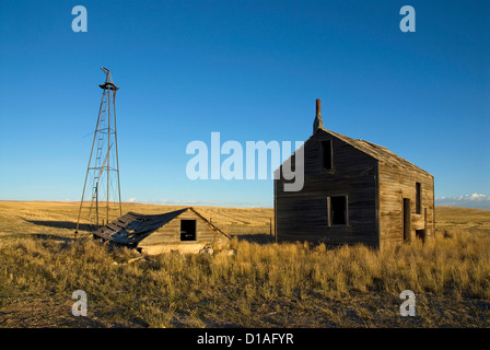 Moulin à vent et les bâtiments d'une ancienne ferme abandonnée dans la prairie du Nord de l'Utah. Banque D'Images