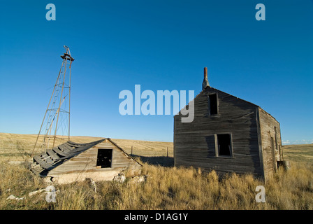 Moulin à vent et les bâtiments d'une ancienne ferme abandonnée dans la prairie du Nord de l'Utah. Banque D'Images