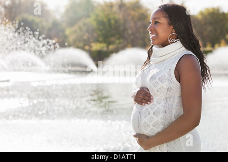 Happy young pregnant woman in park Banque D'Images