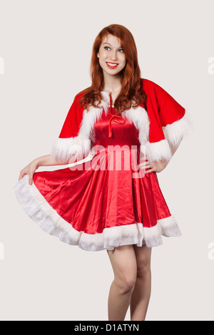 Happy young woman in Santa costume sitting Banque D'Images