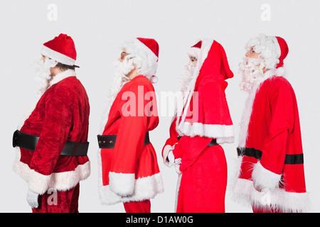 Les gens en costume père noël assis dans la rangée Banque D'Images