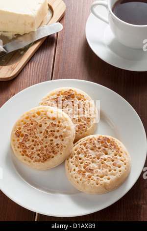 Les Crumpets anglais avec du beurre et du thé Banque D'Images