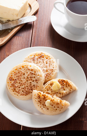 Les Crumpets anglais avec du beurre et du thé Banque D'Images