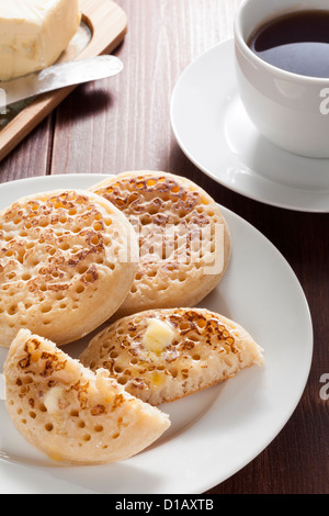 Les Crumpets anglais avec du beurre et du thé Banque D'Images