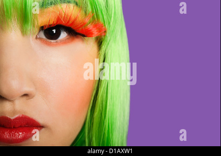 Portrait jeune femme portant de faux cils fond violet Banque D'Images Portrait jeune femme portant de faux cils fond violet Banque D'Images