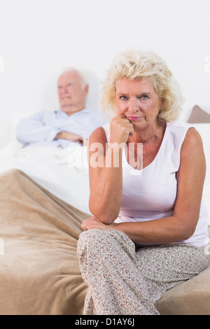 Déçu vieille femme assis Banque D'Images