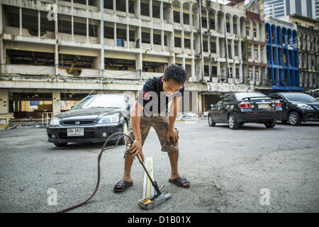 11 décembre 2012 - Bangkok, Thaïlande - un travailleur utilise un chalumeau pour séparer les métaux recyclables dans ''Washington Square'' un célèbre quartier des divertissements de Sukhumvit Soi 22 à Bangkok. Les travailleurs du chantier de démolition sur de nombreux projets en Thaïlande en direct sur leur site d'abattre l'édifice et de recyclage que peut-recyclés comme ils le font jusqu'à ce que le site n'est plus habitable. Ils dorment sur les étages des bâtiments ou parfois dans des tentes, la cuisson au gaz ou des réchauds à charbon travaillant du matin au soir. Parfois les familles vivent et travaillent ensemble, d'autres fois seulement les hommes. Washington Square est l'un des Ba Banque D'Images