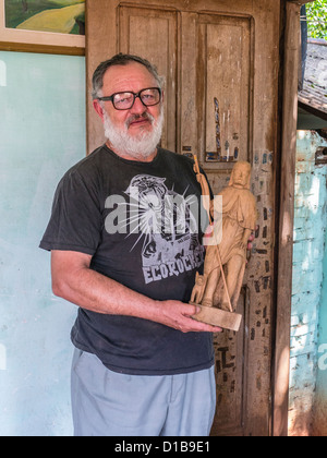 La paraguayenne sculpteur Carlos Rodríguez à tenir l'une des maisons santos il sculpte dans son magasin à Udine, au Paraguay. Banque D'Images