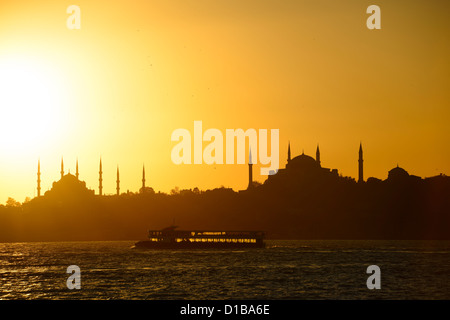 Mosquée Bleue et Sainte-Sophie minarets silhouettes au coucher du soleil sur le Bosphore à Istanbul Turquie bateau rétroéclairé Banque D'Images