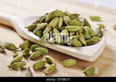 Cardamomes vertes sur fond de bois closeup Banque D'Images