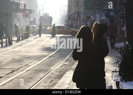 Sofia, Bulgarie, 14 décembre 2012. Deux femmes dans des manteaux d'hiver attendent le tramway dans le centre de Sofia, sur un matin glacial. Les températures dans l'ouest de la Bulgarie a chuté à des niveaux record au cours de l'actuelle vague de froid. Credit : Johann Brandstatter / Alamy Live News Banque D'Images