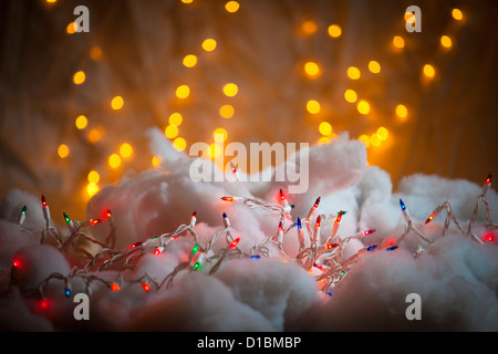 Un brin coloré de lumières de Noël sur tissu neigeux Banque D'Images