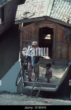 Cachemire, Dal Lake. Un homme lève la location de son bateau et dit au revoir à sa petite fille Banque D'Images