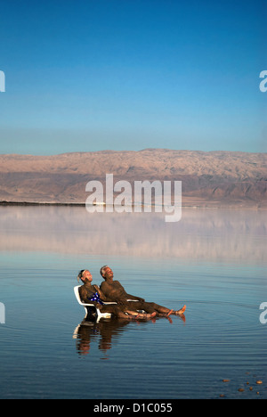 Israël, la Mer Morte. Un couple est couvert de boue curative à la mer Morte en Israël. Banque D'Images