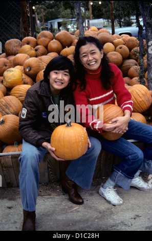 Chinesewoman et fils posent avec des citrouilles à pumpkin farm pendant la saison de l'action de l'automne Banque D'Images