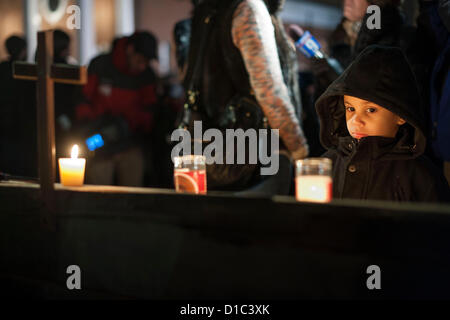 Newtown, Tc - 14 décembre 2012 - Un jeune garçon a l'air à l'extérieur des bougies d'une veillée pour les victimes de la fusillade à l'école élémentaire de Sandy Hook à Newtown CT., tenue à l'église Sainte Rose de Lima à Newtown, TC 14 décembre 2012. (Photo par Gordon M. Grant/Alamy Live News) Banque D'Images