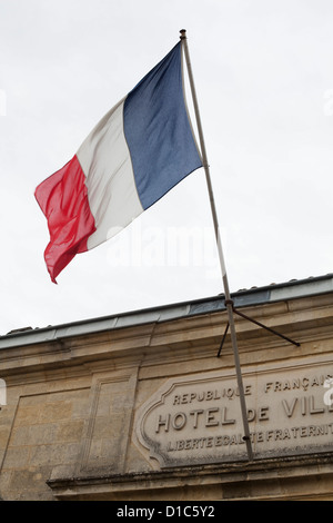 Drapeau français battant au-dessus de l'Hôtel de Ville, St Emilion, France Banque D'Images