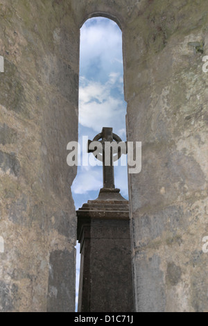 Croix celtique à travers une vieille église fenêtre arch Banque D'Images