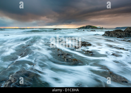 Les rivages rocailleux de Bantham au crépuscule, vue vers l'Ile de Burgh. Banque D'Images