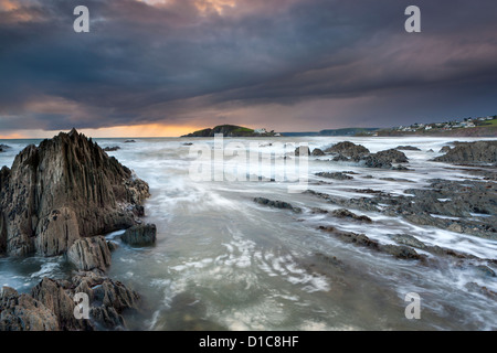 Les rivages rocailleux de Bantham au crépuscule, vue vers l'Ile de Burgh. Banque D'Images