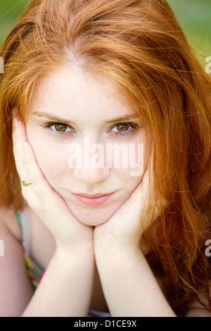 Portrait d'une belle Rousse de 20 ans woman looking at camera avec la tête dans les mains. Banque D'Images
