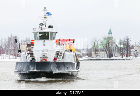 Petit traversier pour passagers entre dans le port d'Helsinki en hiver Banque D'Images