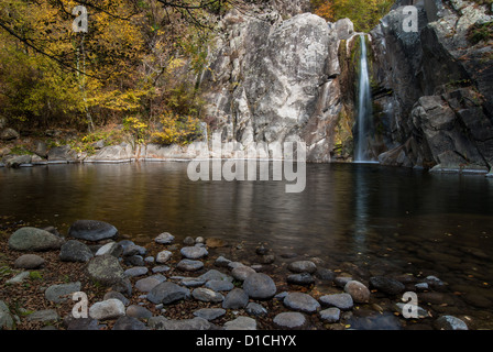 Cascade et petit lac de montagne dans une forêt en automne Banque D'Images