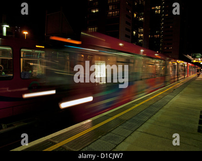 DLR train En arrivant à la station de DLR est de l'Inde dans la nuit, Leamouth district londonien de Tower Hamlets, London, England, UK Banque D'Images