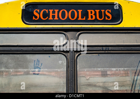 Arrière d'un autobus scolaire indien jaune avec une main sur la fenêtre sale. L'Andhra Pradesh, Inde Banque D'Images