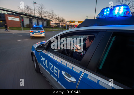 Voiture de police avec feux bleus clignotants, avertisseur sonore, conduite rapide au cours d'une mission d'urgence. Banque D'Images