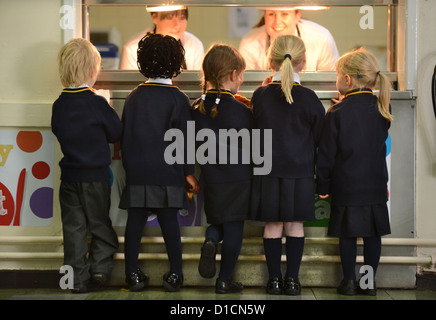 Les écoliers en attente pour toast après matin Assemblée générale à Notre Dame et St Werburgh's Catholic Primary School in- Banque D'Images