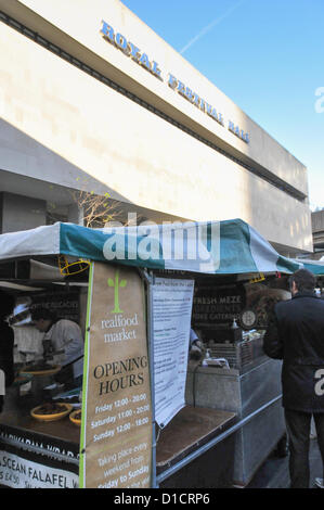 Southbank, Londres, Royaume-Uni. 16 décembre 2012. Le marché derrière la salle des fêtes est rempli de personnes d'acheter et de manger de la viande à produire, fom.gâteaux The Real Food Marché de Noël sur la Southbank derrière le Royal Festival Hall. Les commerçants, les petits agriculteurs et producteurs du monde entier de vendre la meilleure qualité de nourriture et boisson. Banque D'Images