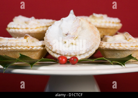 Des petits pâtés sur un cake stand sur un fond rouge. Banque D'Images