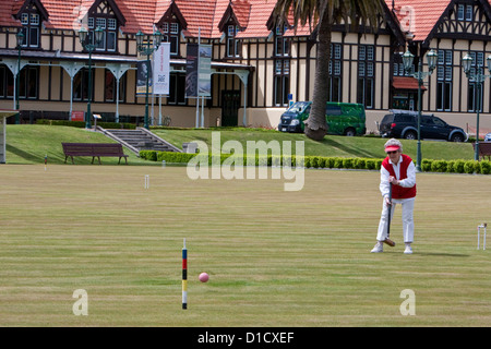 Jouer au croquet dans les jardins, Musée (ancienne station thermale) en arrière-plan. Rotorua, île du nord, en Nouvelle-Zélande. Banque D'Images