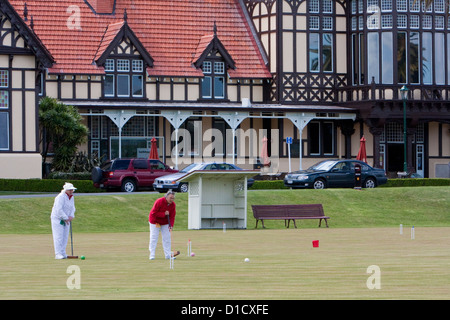 Jouer au croquet dans les jardins, Musée (ancienne station thermale) en arrière-plan. Rotorua, île du nord, en Nouvelle-Zélande. Banque D'Images