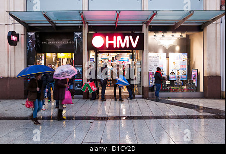 Clients dans la pluie à l'extérieur du magasin HMV, Cardiff, Pays de Galles, Royaume-Uni Banque D'Images