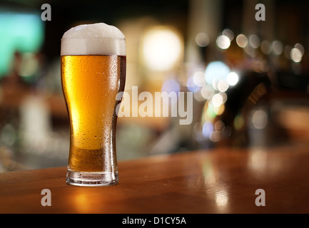 Verre de bière légère sur une pub. Banque D'Images