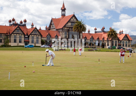 Jouer au croquet dans les jardins, Musée (ancienne station thermale) en arrière-plan. Rotorua, île du nord, en Nouvelle-Zélande. Banque D'Images