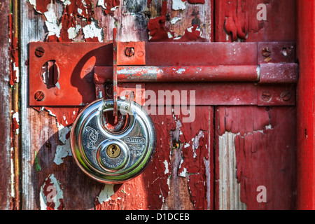 Cadenas flambant neuve sur une vieille porte.jpg Banque D'Images