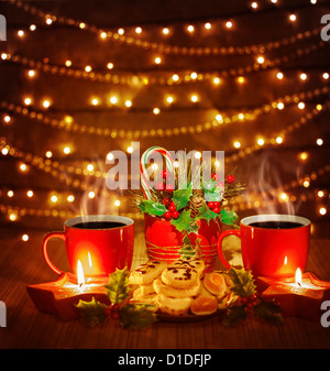 Belle photo de Noël encore la vie, thé rouge tasses avec de délicieux biscuits maison et des bougies sur la table en bois Banque D'Images