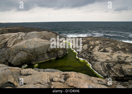 Piscine d'eau salée avec des gisements de sel sur une petite île, avec la mer au-delà, de la côte ouest de la Suède Banque D'Images