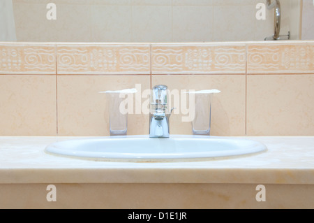 Évier, robinet chrome blanc et deux verres dans une salle de bains de l'hôtel Banque D'Images