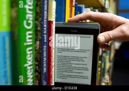 Une illustration en date du 4 décembre 2012 montre un homme de prendre un e-reader à partir d'une étagère dans la bibliothèque centrale de Hambourg en Allemagne. 13 000 e-livres peuvent être empruntés en ligne et lire sur e-lecteurs ou téléphones intelligents. Photo : Alex Ehlers Banque D'Images